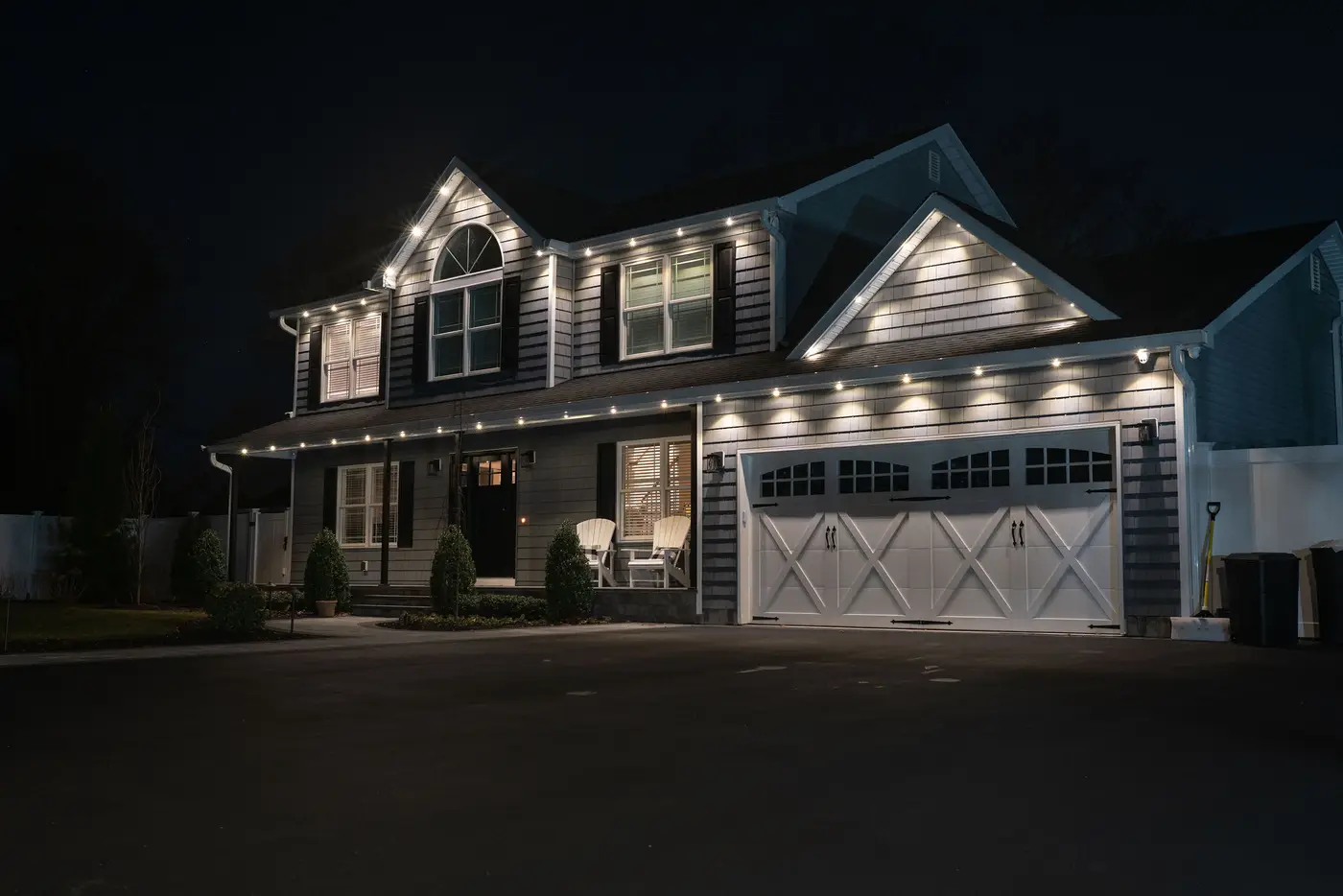 White house at night with permanent roofline lighting in warm white